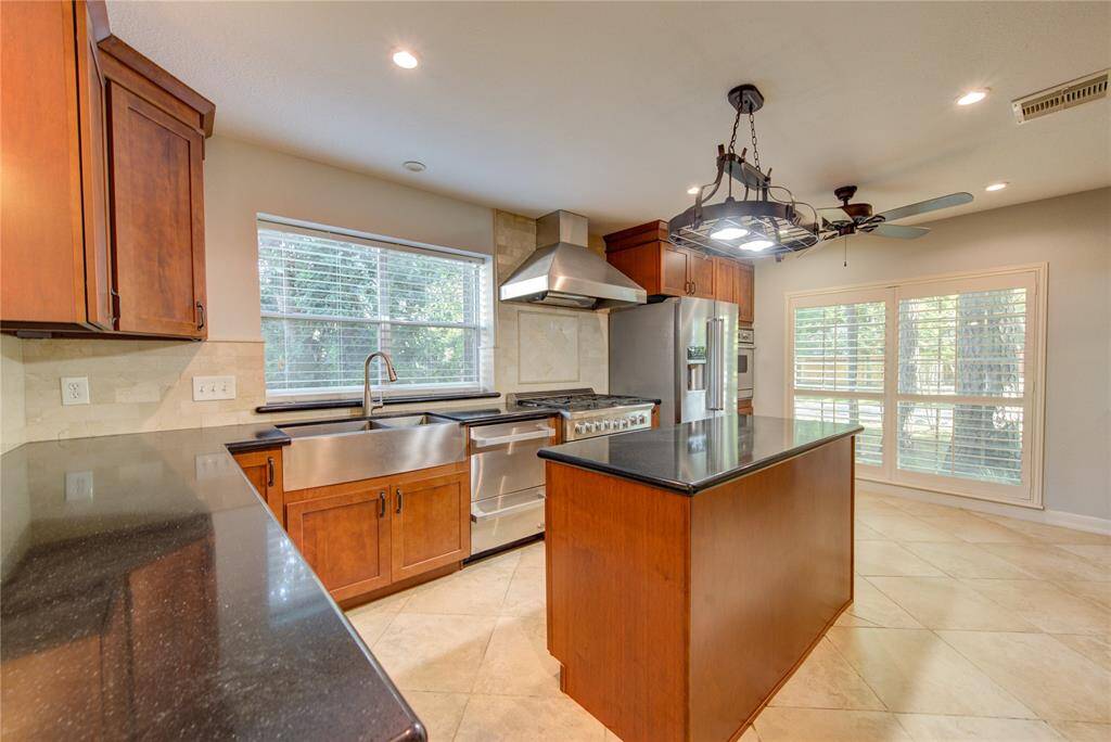 Beautiful kitchen at front of home includes refrigerator, built-in convection oven, 6 burner gas range with large oven & vent hood. Upgraded dishwasher and handy deep double sink with new faucet. Plantation shutters & granite counter tops.