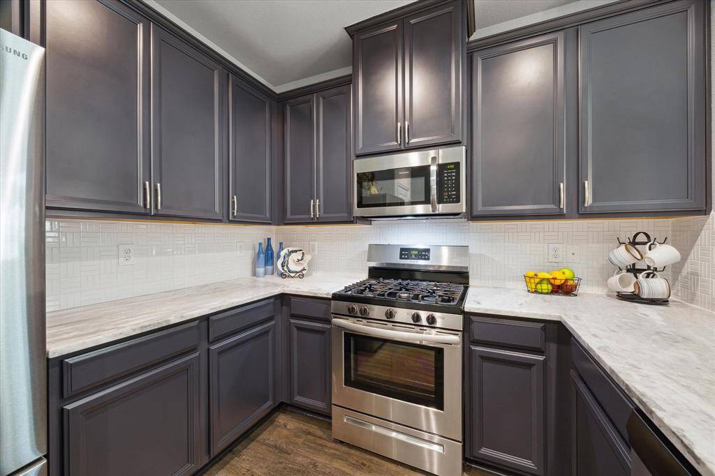 This modern-style Kitchen also boasts of 42-inch Birch wood cabinets and designer backsplash with stainless steel appliances.