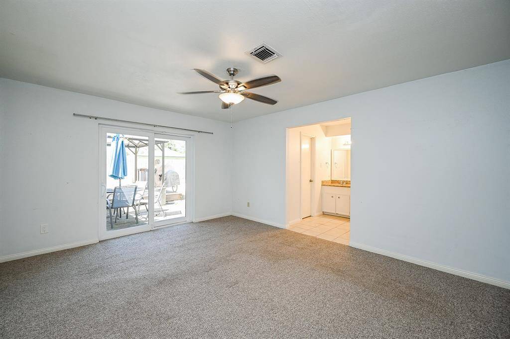 Bright primary bedroom with a sliding door opening to the inviting patio.