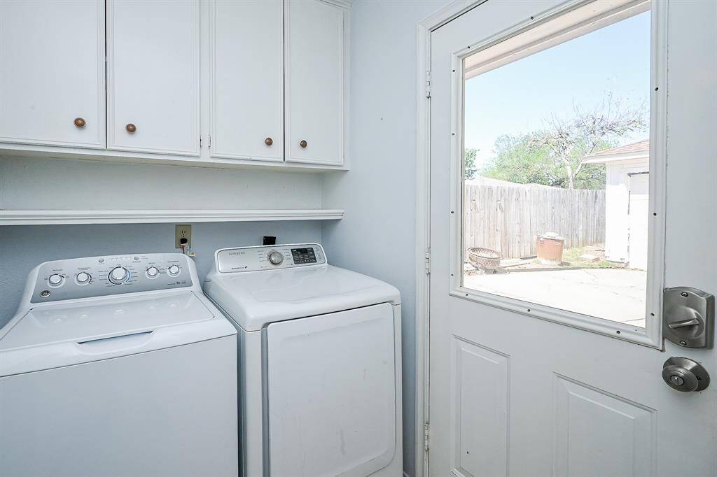 Functional laundry room with ample cabinetry, modern appliances, and convenient outdoor access.