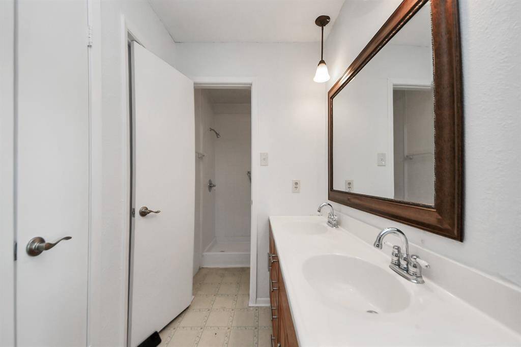 Heading into the primary bathroom, you’ll find a dual-sink vanity with lots of drawers & cabinetry, and a linen closet.
