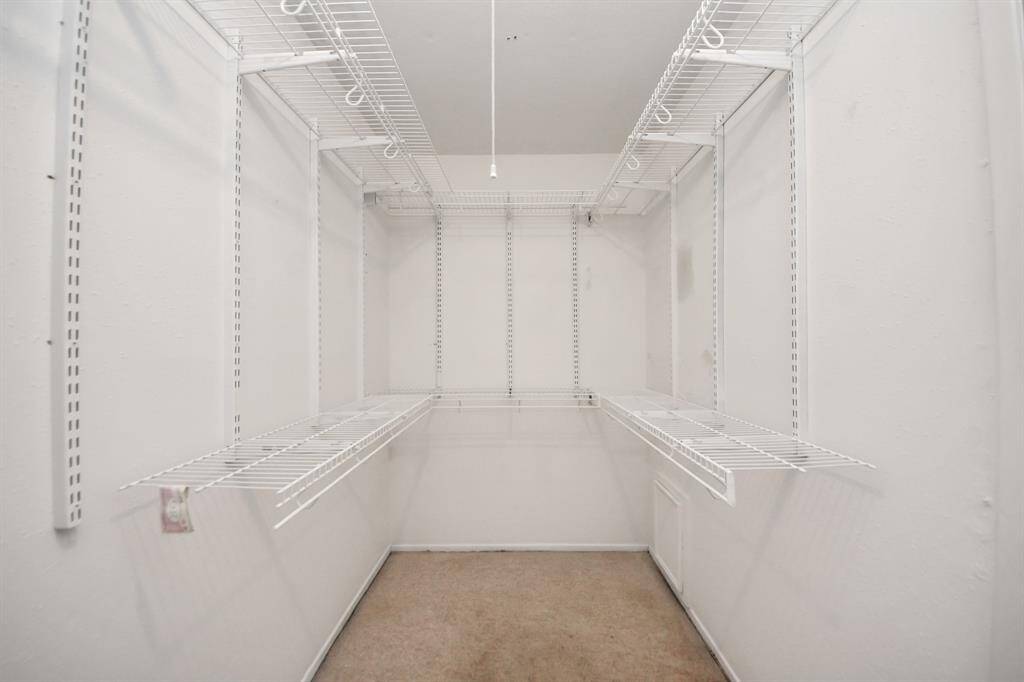 The primary suite offers a large walk-in closet with built in racks.