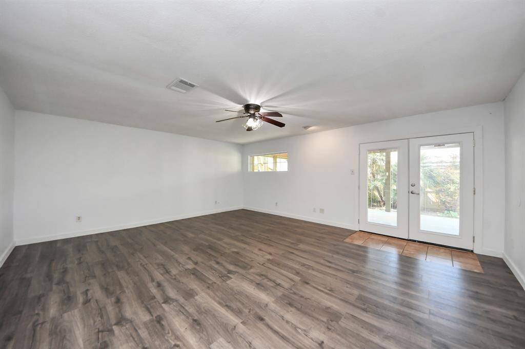 The spacious living area features durable flooring replaced in 2025, a ceiling fan for added comfort, and double glass doors that open to a covered patio!