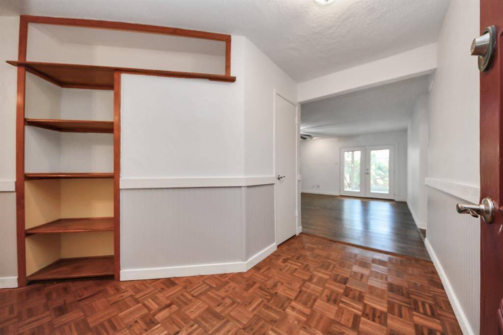 Step into the home through a welcoming entryway featuring wood flooring and built-in shelving, perfect for storage and display. Just ahead, a convenient coat closet adds to the functionality of this inviting space.