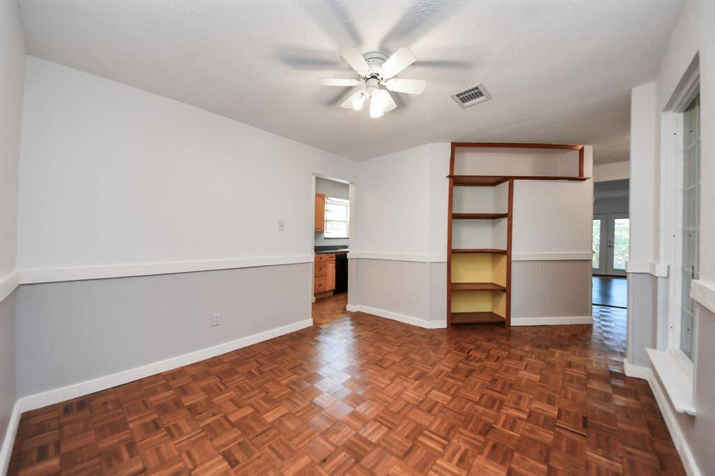 To the left of the entryway is a bonus space with ceiling fan overhead, chair rail molding along the walls, and a window that looks out toward the side of the home. Can be used as a formal dining area, office space, playroom, etc!