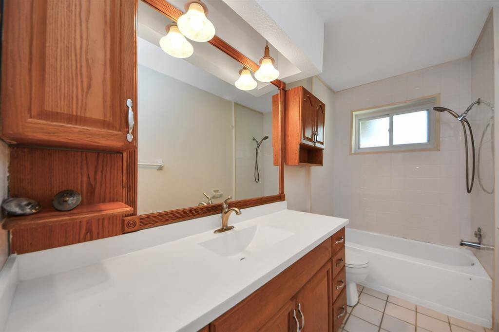 The guest bathroom features a spacious vanity with plenty of storage and a convenient shower/tub combo. Shower tiles that go up to the ceiling and a frosted window for privacy.