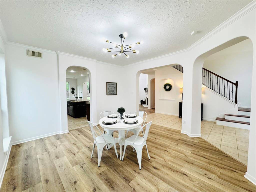Another view of this large space, it seamlessly connects to the kitchen and living spaces, with elegant archways and a view of the staircase! Perfect for family gatherings!