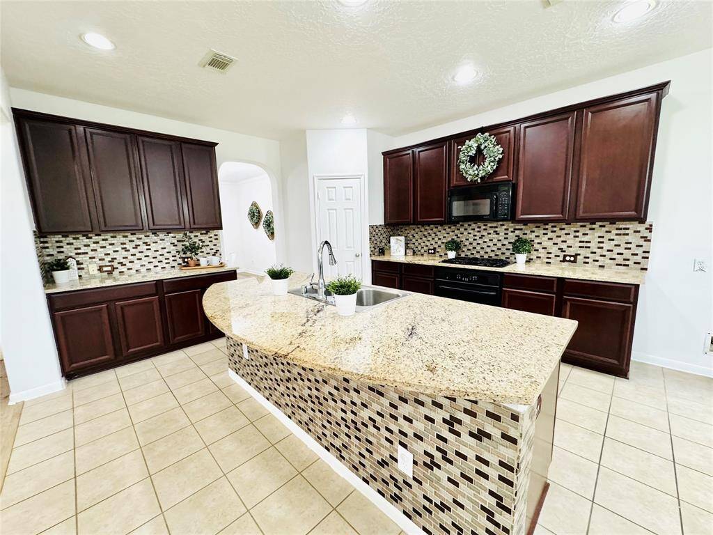 A close up view of this Chef's Kitchen! There is plenty of prep space and sleek black appliances!
