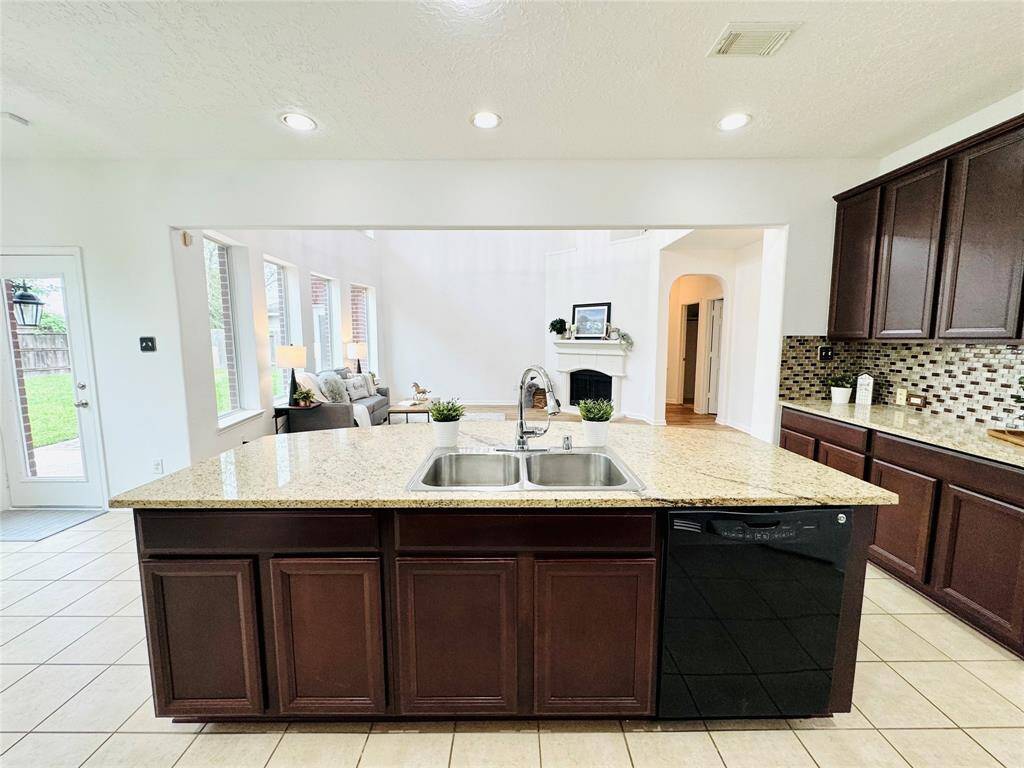 The granite island is huge with a double-bowl stainless steel sink, nickel faucet/sprayer, garbage disposal, and built-in dishwasher!