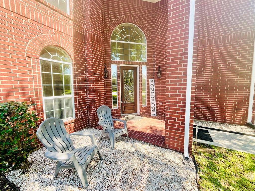 The roomy, yet cozy porch features a brick base, and a landscaped area with two Adirondack chairs perfect for relaxation!