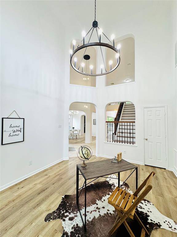 Another view of this gorgeous flex space with updated chandelier (2024), updated LVP wood flooring (2024), and updated wall and trim paint (2024)! It also does have a closet for additional storage!