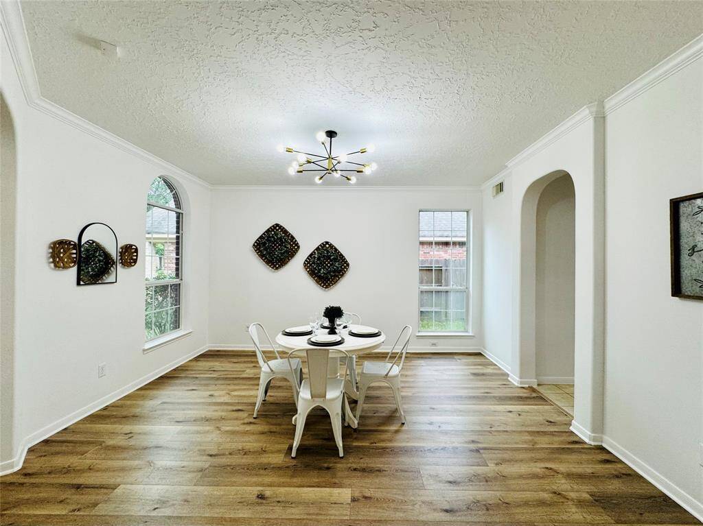 The delightful dining room has had updates as well; light fixture (2024), updated LVP wood flooring (2024), and updated wall and trim paint (2024), double pane Low E windows, Such an inviting atmosphere for gatherings!