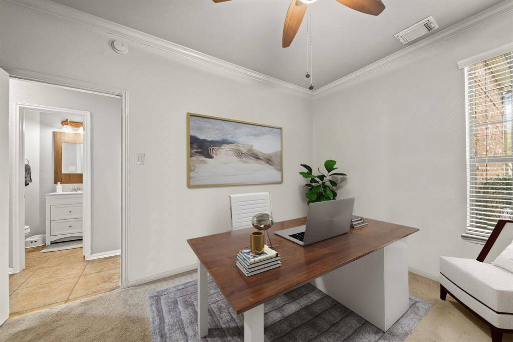 Virtually Staged: This charming home office is the perfect place to read your favorite book or get some work done! Featuring carpet floors, windows with privacy blinds, a ceiling with fan, and crown molding details.