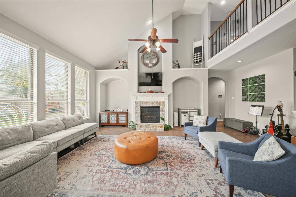 This stunning living room features tile floors, and a gorgeous fireplace with mantle.