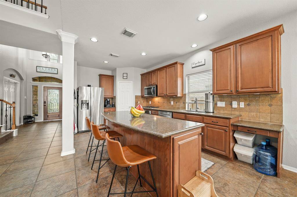 Host your next dinner party with confidence. This masterfully-equipped kitchen features a kitchen island with breakfast bar, an abundance of cabinetry and hardware, TONS of counter space, granite countertops and stainless-steel appliances.