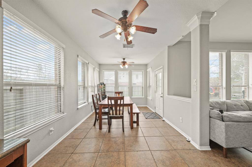 Charming breakfast area, complete with tile floors, ceiling fans, and beautiful views of the backyard provided by several windows with privacy blinds.