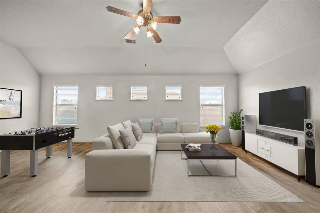 Virtually Staged: Fantastic spacious game room located conveniently upstairs! Featuring a high ceiling with a ceiling, wood floors, and multiple windows with privacy blinds.