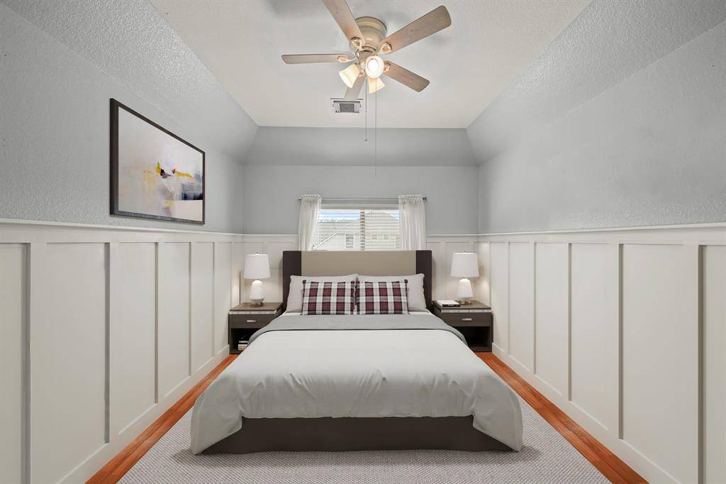 Virtually Staged: Secondary bedroom with wood floors, a tray ceiling with a ceiling fan, and a window with privacy blinds.