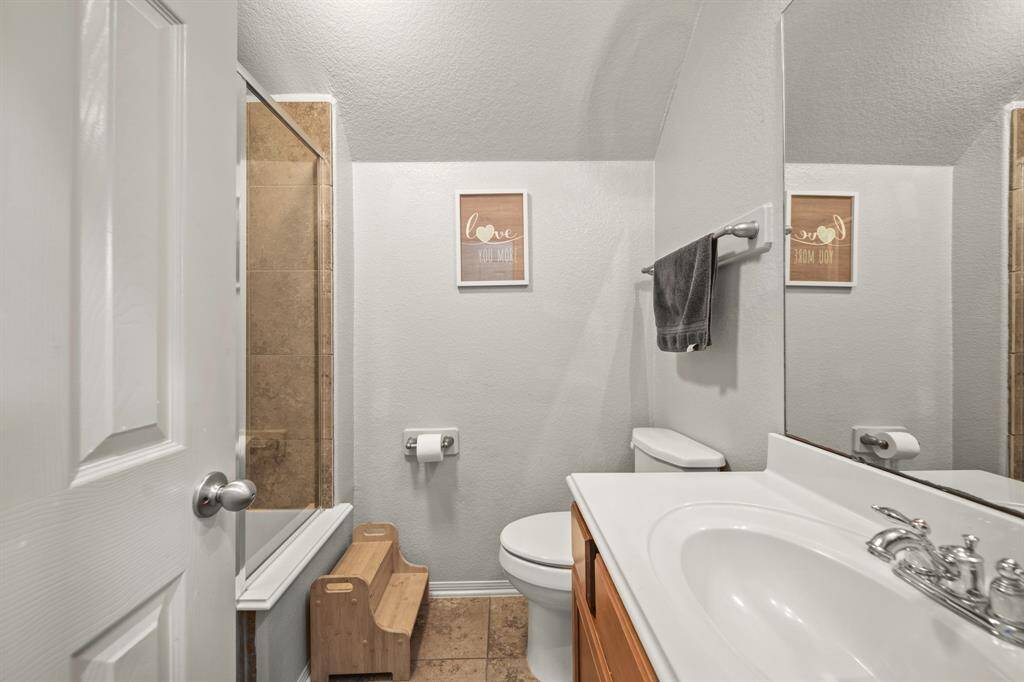 Secondary bathroom with tile floors, granite countertops and backsplash, and a walk-in shower.