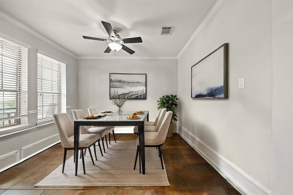 Virtually Staged: Spacious dining room with tile floors, crown molding details, windows with privacy blinds, and a ceiling fan.
