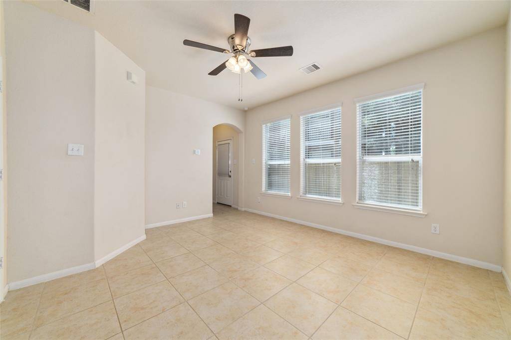 Large first floor en-suite bedroom equipped with tile flooring and ceiling fan.