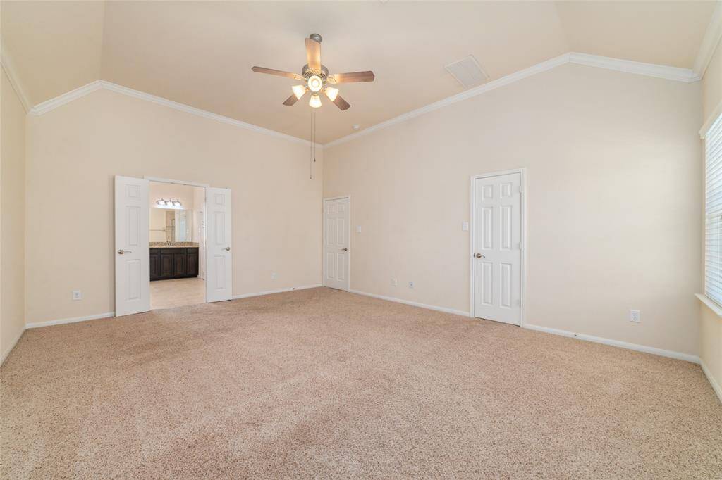 Large primary 3rd floor bedroom with crown molding, walk-in closet, and plush carpe flooring.