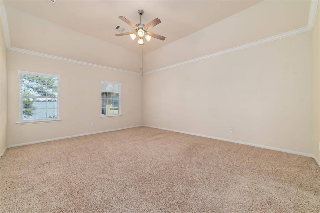 Large primary 3rd floor bedroom with crown molding, walk-in closet, and plush carpe flooring.
