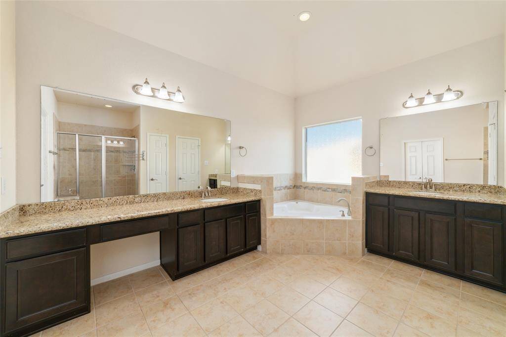 Dual vanity granite sinks with a garden soaking tub.