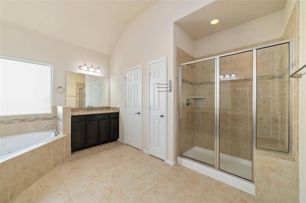 Primary bathroom also features a large walk-in shower with a bench.