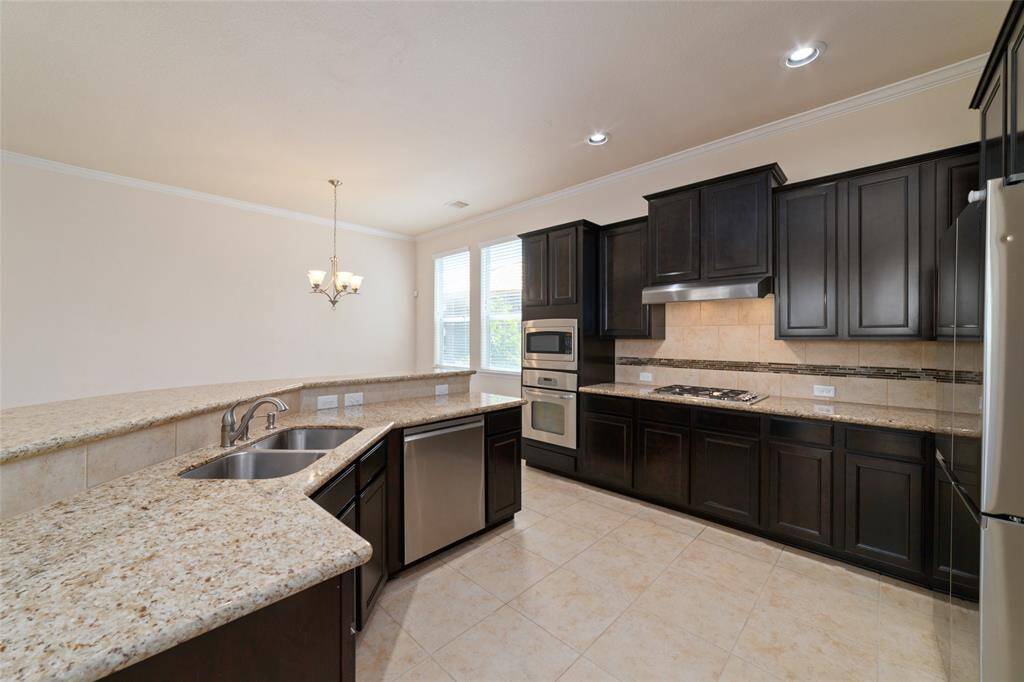 The kitchen features granite countertops, stainless steel appliances, gas range, and dark wood shaker cabinets for storage.