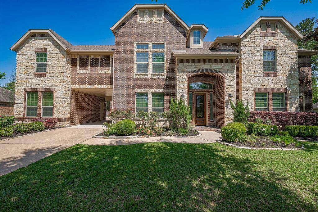 This impressive home features a blend of brick and stone exterior with a welcoming entrance and well-maintained landscaping. The spacious driveway leads to an attached garage, and the lush front lawn adds to its curb appeal.