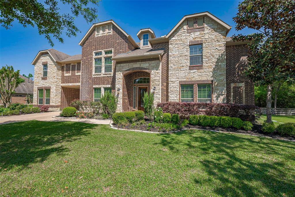 This beautiful home features a classic brick and stone exterior with elegant architectural details. It boasts large windows for ample natural light and a welcoming front porch. The well-maintained landscaping includes lush greenery and a manicured lawn, creating great curb appeal. Perfect for family living.