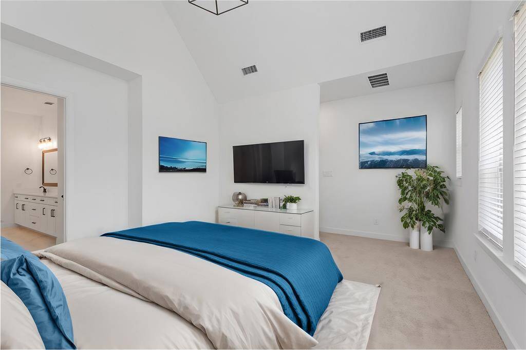 Vaulted ceiling and transom windows on wall behind bed (virtually staged)