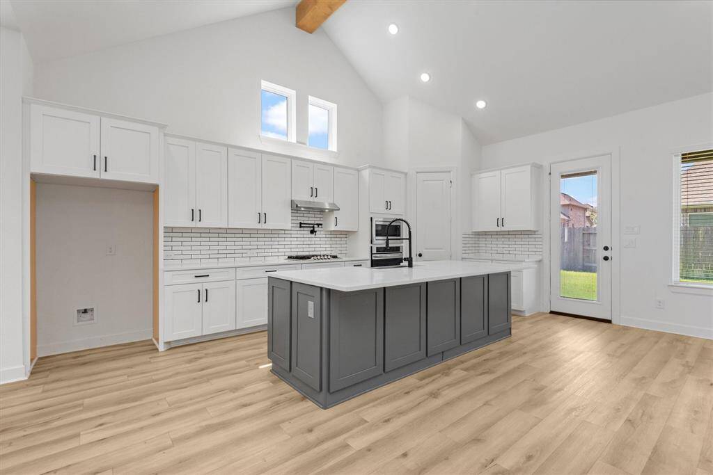 Ample amount of cabinetry throughout island kitchen with Quartz countertops & subway tile