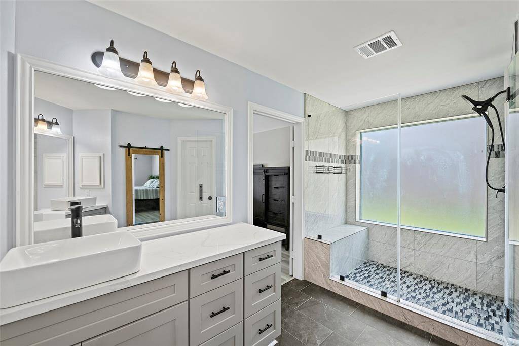 The fully remodeled primary bath just WOW's from the minute you walk-in!  Can we take a moment to peep at this amazing OVERSIZED shower with bench seat and detachable shower head?  This is so dreamy!