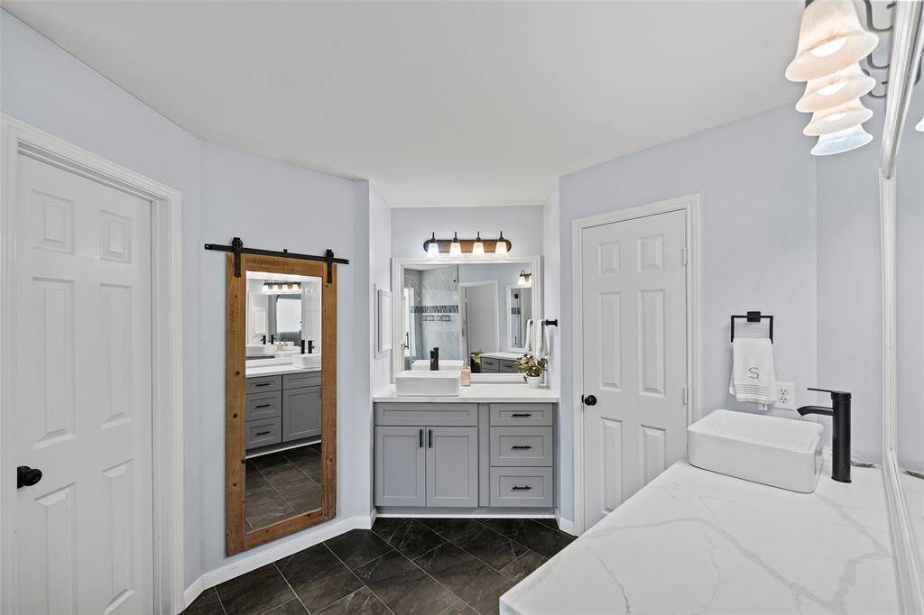 This bathroom features dual vanities with vessel sinks that offer beauty and function to this space!
