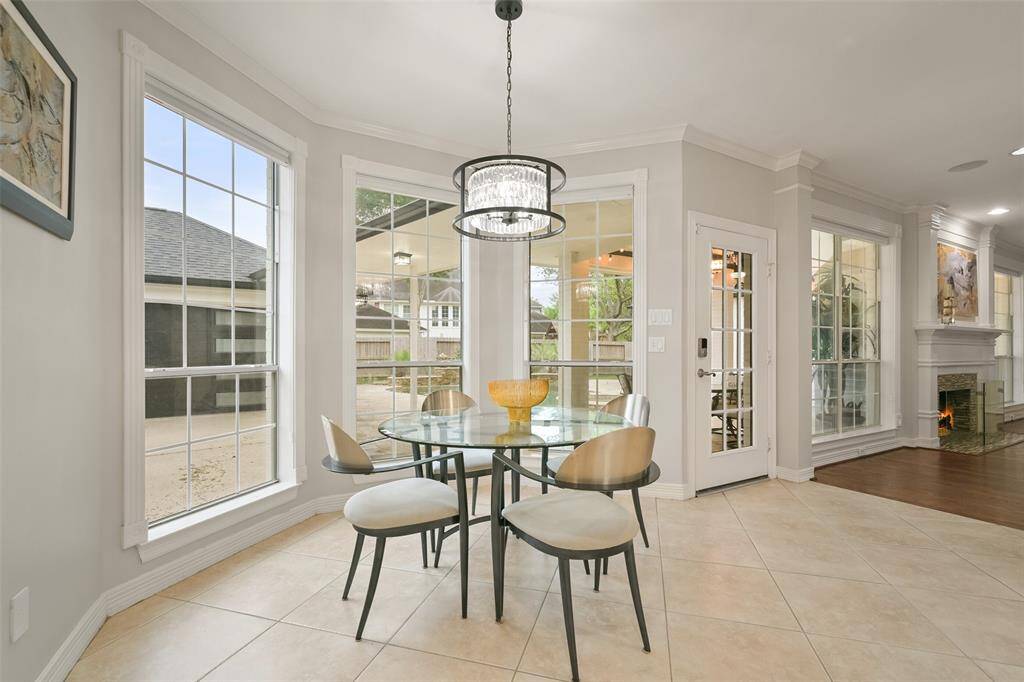 Light and bright Breakfast nook featuring large windows, a modern chandelier, and has access to the patio, enhancing indoor-outdoor flow.