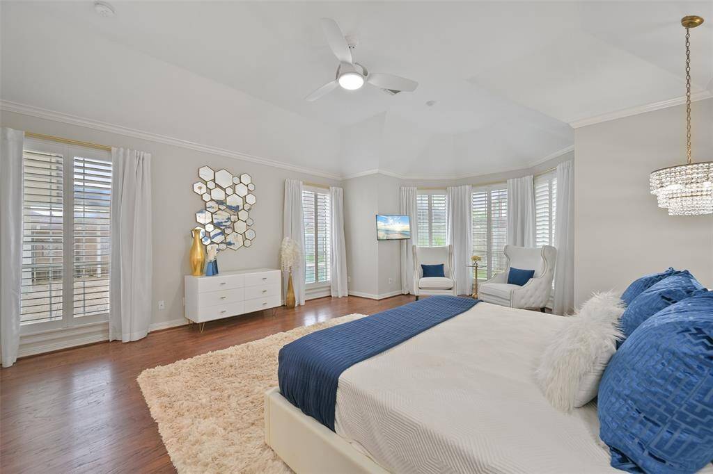 Another view of the Primary suite with windows with plantation shutters overlooking the beautifully landscaped backyard, pool and spa.