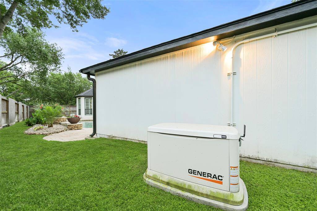 A full-house generator on the side of the neatly maintained backyard providing peace of mind and convenience.
