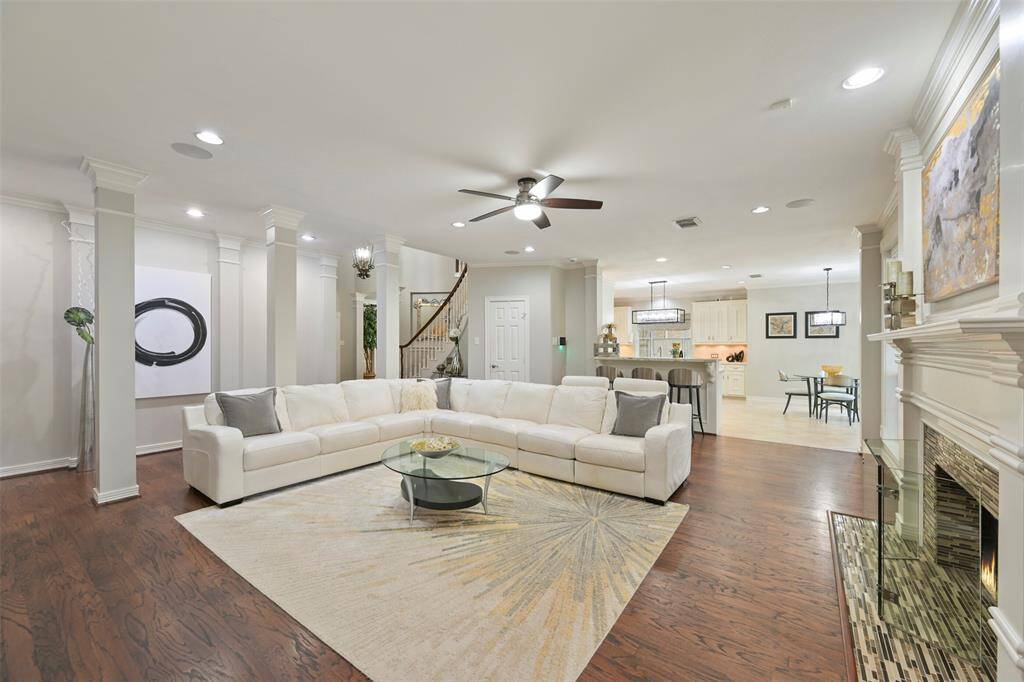 Another view of the Family room seamlessly flowing into a modern kitchen with a breakfast bar and informal dining area, perfect for entertaining. Ample natural light enhances the warm, welcoming ambiance of this room.