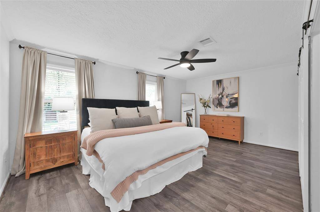The Primary Suite has plenty of room for King-sized furniture sets and stays bright with two windows covered with faux wood blinds.