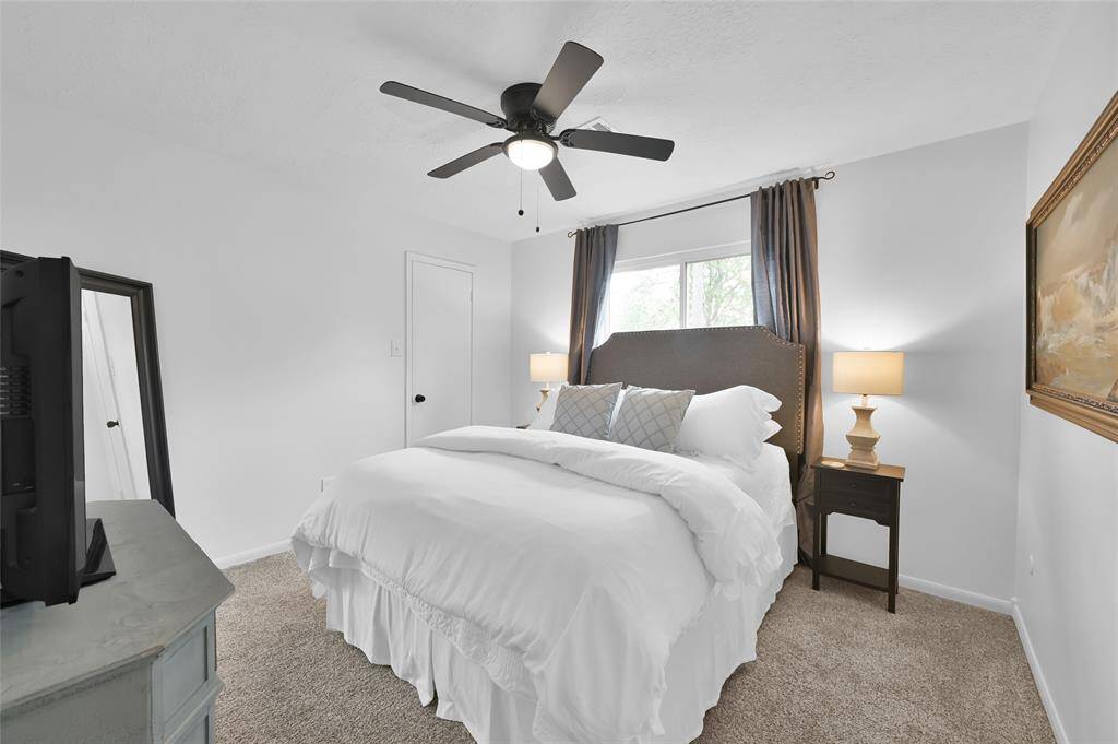 This Secondary Bedroom overlooks the Back Yard, has a ceiling fan with light and a generous walk-in closet.