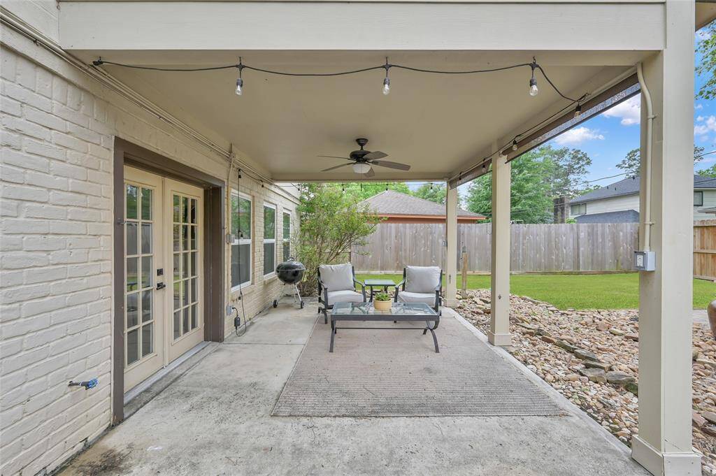 Exit the French Doors off the Living Room to relax under a covered patio with ceiling fan with light and additional string lights the seller is leaving. Shades also help keep out the sun when you prefer a little break.
