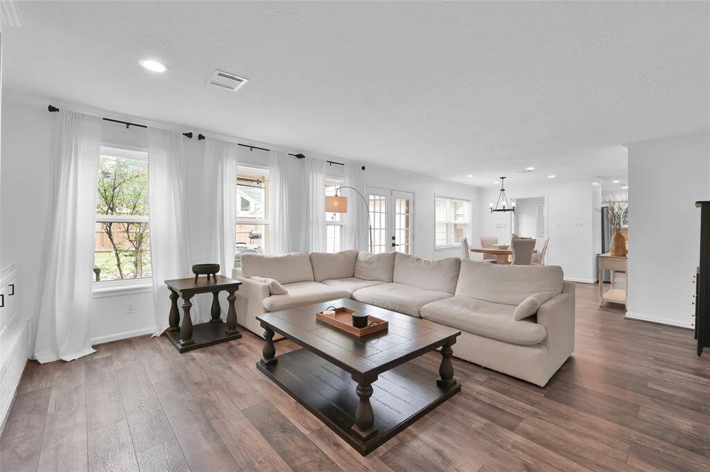 The Living Room also has Glass Panel French Doors providing easy access to the Back Yard along with a wall of double pane windows.