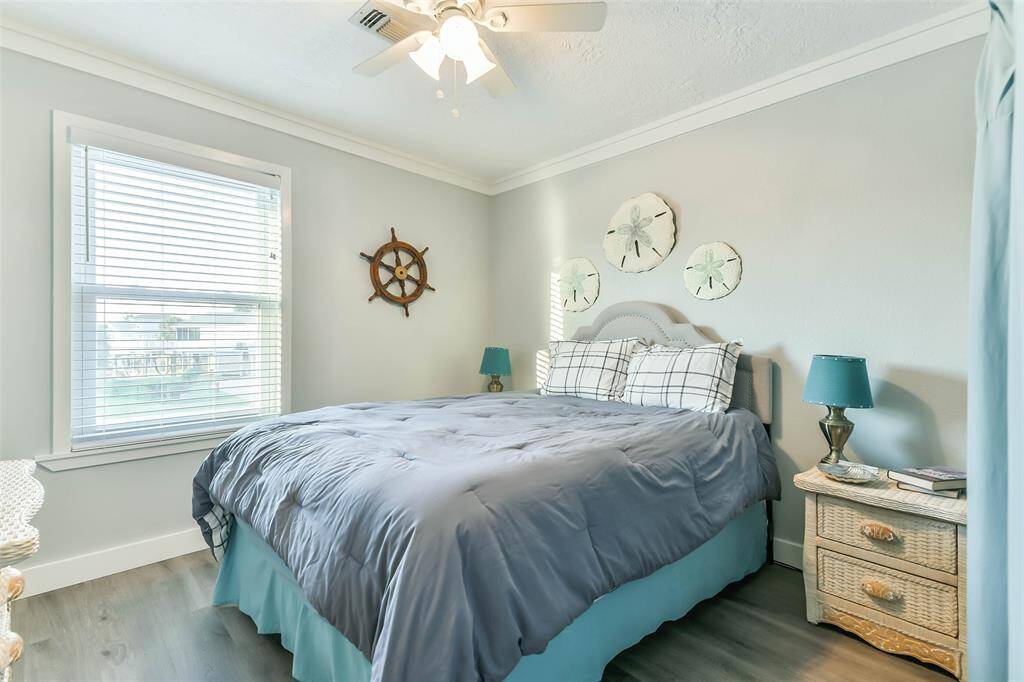 Bedroom #2 features elegant crown molding, two-inch blinds, and a ceiling fan equipped with a light fixture.