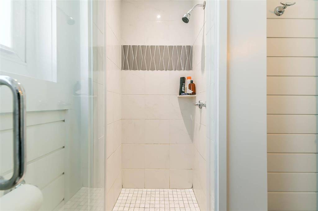 The hall bathroom features a beautifully tiled enclosed shower.