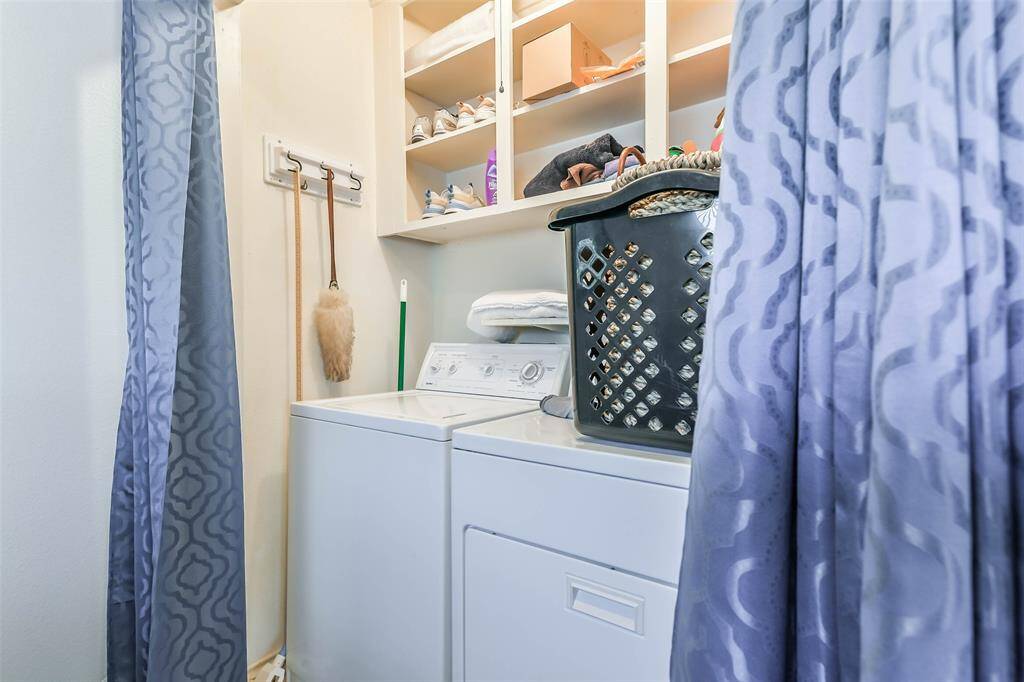 The laundry room features storage shelves for added organization.