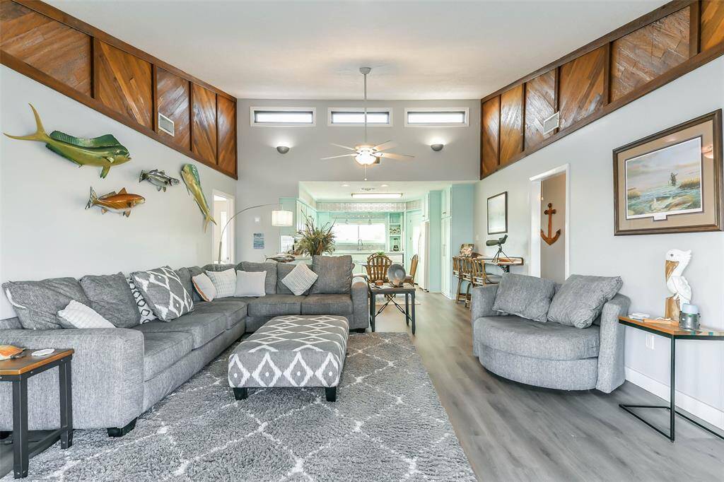 Spacious open-concept home featuring high ceilings, a ceiling fan with an elegant light fixture, and recessed lighting for a warm ambiance.