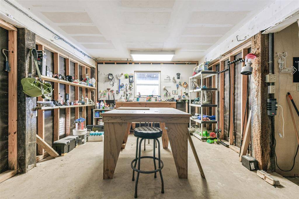 A garage workshop equipped with a workbench and storage shelves.