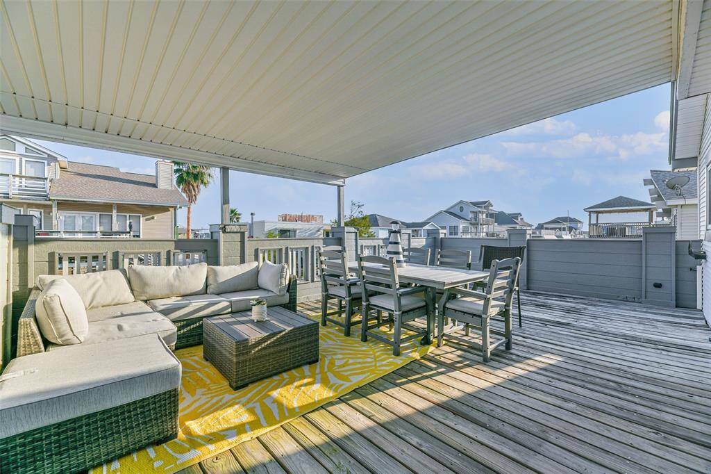A covered patio deck extends from the upstairs living area.